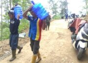 Penghilang Dahaga, Warga Suguhkan Air Mineral Untuk Anggota Satgas TMMD Reg ke 122.